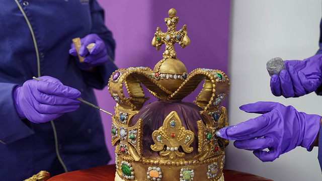 <p>Cadbury World chocolatiers add the finishing touches to a 45cm tall chocolate replica of St Edward's Crown, which was used at the coronation of King Charles III</p>